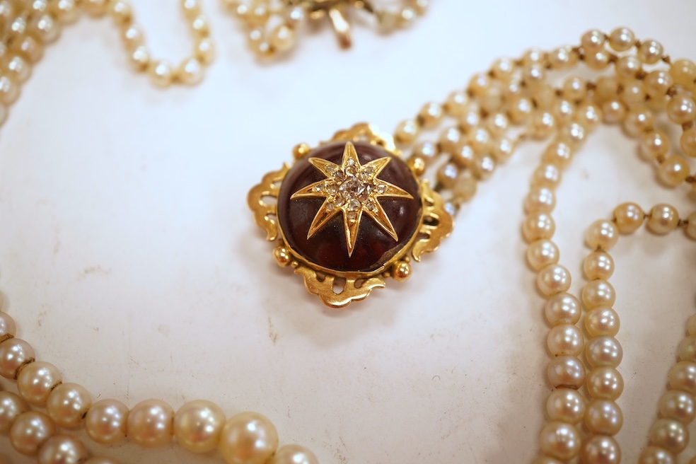 Two necklaces, comprising: a three-strand cultured pearl necklace, to a cabochon garnet and diamond clasp, length 34cm; and a paste and gilt metal pendant on a gold chain, chain length 44cm, stamped 14K, gross weight of